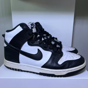 Svartvita Nike Dunk sneakers - Säljer ett par klassiska svartvita Nike Dunk High sneakers i storlek 41. Bra skick, använda några gånger. Därav lite creasing.
