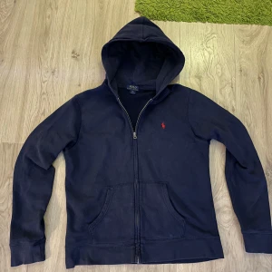 Ralph lauren ziphoodie - Tja säljer denna feta marinblåa ralph lauren ziphoodie pga att den inte används längre. Den e i bra skick o tveka inte på att höra av dig vid funderingar eller flera bilder. Den är storlek 18-20 vilket är typ S men funkar även till M