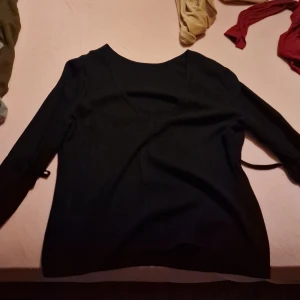 Svart långärmad tröja - Säljer en stilren svart långärmad tröja. Perfekt för både vardag och fest. Tröjan har en enkel design med en bekväm passform. Passar bra till jeans eller kjol för en avslappnad look.