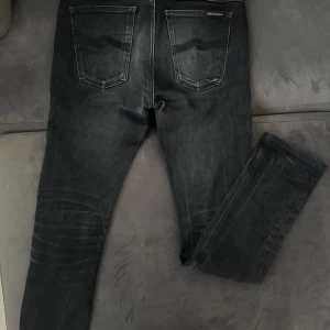 Nudie Jeans - 	Svarta slim fit jeans, storlek 31/32. Sparsamt använda och i toppskick. Stretchigt material för optimal passform. Passar alla tillfällen och är ett måste i garderoben! Kan hämtas eller skickas.