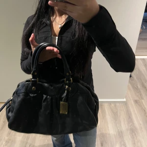Marc Jacobs väska  - En stor väska som rymmer mycket. Den håller sig i fin form, oavsett om den är tom eller full. Väskan är i nästintill perfekt skick med endast några små fläckar inuti och vanligt slitage på kanterna (fler bilder kan skickas privat)🩷 