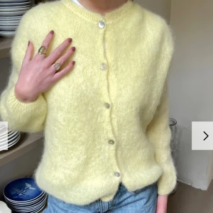 Gul fluffig kofta - Säljer en supermysig gul kofta som är perfekt för både vår och sommar. Den är fluffig och har en härlig, mjuk känsla. Koftan har långa ärmar och knäpps med knappar framtill. Perfekt att slänga på sig över en t-shirt eller linne för en avslappnad look. 💛