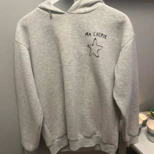 Grå hoodie - Knappt använd grå hoodie med trycket ”ma cherie” på bröst och ryggen. 