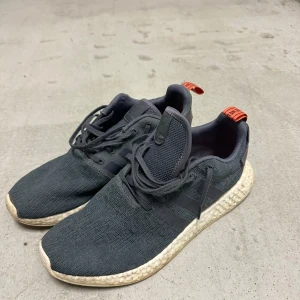 NMD Adidas  - Gråa NMD. Relativt slitna på vita sulan annars ganska fint skick. 