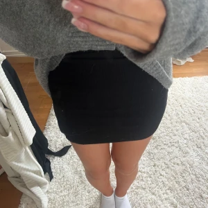 Svart kort kjol - En tajt kort kjol från kids brand store! Så fin till en stickad tröja med boots till🥰 kan passa storlek xs till m.