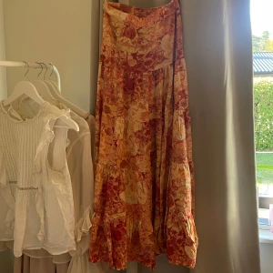 Mönstrad kjol - En fin blom-mönstrad maxikjol i rosa-orangea nyanser från Auguste the label. Köpt second hand men jag ser inget fel alls på den och har använt den någon gång bara. En liknande kjol i nyskick från samma märke kostar cirka 1200kr.
