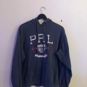Ralph lauren hoodie stl M - Snygg unik blå/grå polo Jeans company hoodie i storlek M. Lågt pris på grund av diverse defekter som det finns bild på i annonsen (Har inte testat att ta bort fläcken). Annars snygg som fan! Hör av er vid frågor eller funderingar!