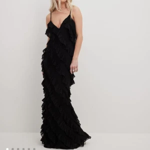 Volangklänning - Volangklänning från NAKD, svart i nyskick, prislappen finns kvar. Aldirg använd!  Nypris 599kr Bra till bal, gasque, som finklänning, maxiklänning, fest osv