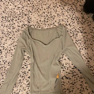 Grön topp - Jättemjuk grön topp med v ringning, samt slits på sidorna som går upp magen. Jättesnygg och oanvänd topp med prislapp. 🤍