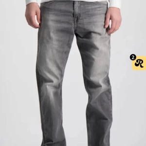 Replay Thad jeans - Replay jeans modell Thad i grå nyans, storlek 160. Jeansen har raka ben, normalhög midja och gylfen består av knapp och dragkedja. 