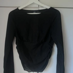 Svart glittrig topp från Shein - Säljer en snygg svart glittrig topp från Shein i storlek L. Perfekt för festliga tillfällen med sin glittriga yta och långa ärmar. Toppen har en figurnära passform och är i nyskick med etiketten kvar. Passar perfekt till både jeans och kjol för en glam look! ✨