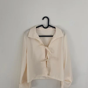 Vit topp med knyten  - Oanvänd vit topp med knuten! Väldigt lik den från djerf avenue. Saknar lappar, men skulle säga att den passar en XS/S!