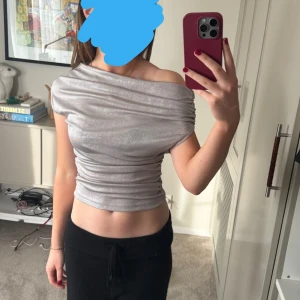 Topp - En silvrig, asymmetrisk festtopp från zara. Aldrig använd och är därför i nyskick💕💕
