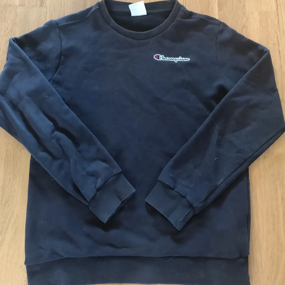 Säljer en svart sweatshirt från Champion i bra skick. Storlek X- Large för barn (162/167cm)Den har en klassisk design med Champion-loggan broderad på bröstet och ärmen. Perfekt för en avslappnad stil och passar till alla säsonger. Skön och bekväm med ribbade muddar vid ärmslut och nederkant.. Tröjor & Koftor.