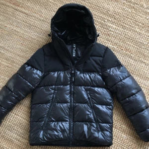 Svart pufferjacka från Replay - Säljer en snygg o skön jacka från Replay! Jättebra skick förutom ett litet hål inuti ena fickan men inget som syns. Nypris 2999kr!