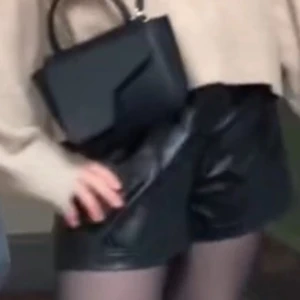 Svarta läder/skinn shorts  - Storlek S som en vanlig S. Högmidjade men viker ner dem och har en längre tröja till 