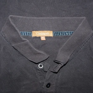 Svart pikétröja från Conbipel - Säljer en klassisk svart pikétröja från Conbipel i storlek XL. Tröjan har långa ärmar och en stilren krage med knappar. Perfekt för både vardag och lite mer uppklädda tillfällen. Skön och enkel att matcha med det mesta i garderoben.