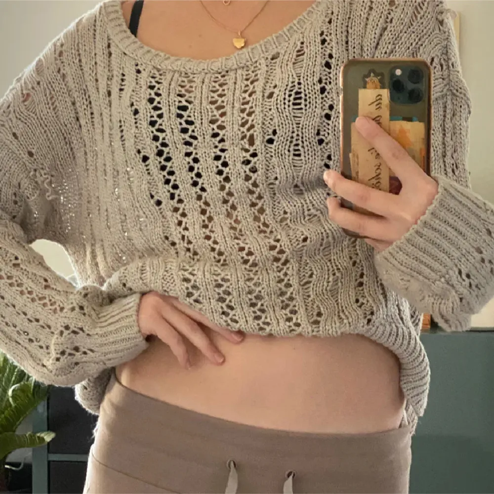 Säljer en superfin beige stickad tröja med ett luftigt mönster. Den har en avslappnad passform och långa ärmar, perfekt för lager på lager-stil. Tröjan är mjuk och skön, idealisk för både höst och vår. Passar perfekt till jeans eller leggings för en chill look.. Neuletakit & Villapaidat.