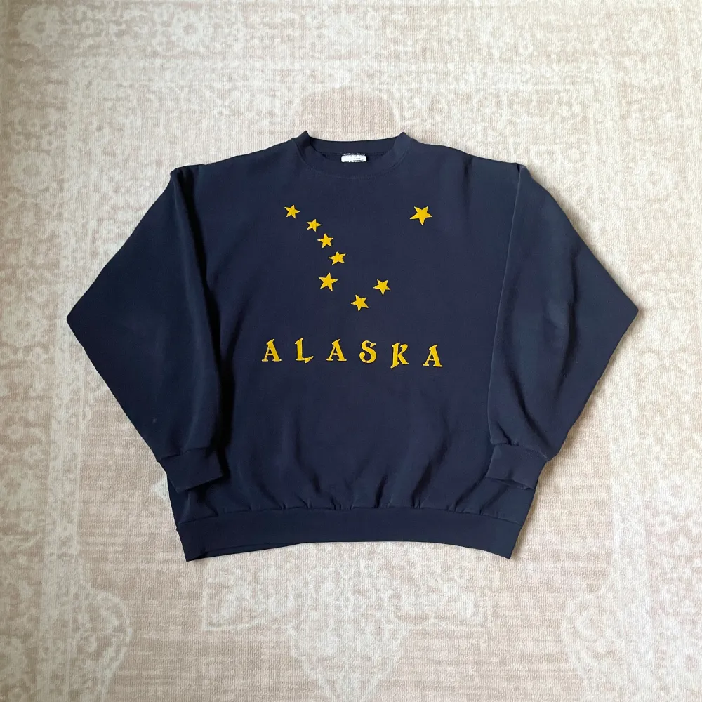 Vintage Alaska tröja med tryck i gult. Tröjan är i bra skick och perfekt för höst och vinter. Den är gjord av en skön blandning av bomull och polyester, vilket gör den både varm och gosig. . Tröjor & Koftor.