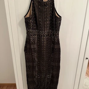 Svart spetsklänning från Oasis - Säljer en elegant svart spetsklänning från Oasis i storlek L. Klänningen har ett vackert spetsmönster och är ärmlös med en smickrande passform. Perfekt för festliga tillfällen! 🖤använd en gång
