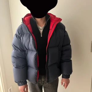 Mörkblå pufferjacka från Colmar - Säljer en snygg mörkblå pufferjacka från Colmar med röd insida. Jackan har en dragkedja framtill och är perfekt för kalla dagar. Den är i mycket bra skick och har en normal passform. Perfekt för vintern! ❄️.      Storlek S men stor i storleken passar M!