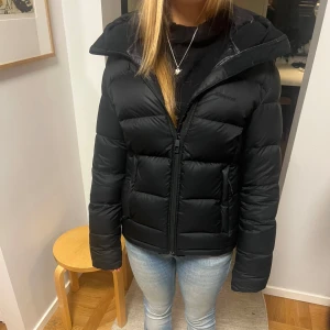 Svart dunjacka från Everest - Säljer en svart dunjacka från Everest i bra skick. Jackan har en inbyggd reflex i ena fickan som man kan dra fram om man vill (bild 5) och är perfekt för kalla dagar. Finns en liten DEFEKT som absolut inte syns som jag kan skicka bild på. Använd en vinter, men fortfarande i bra skick! Älskar jackan, men säljer då jag köpt en ny. Nypris 2500kr. Pris kan diskuteras!💗