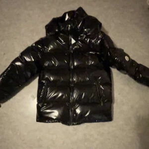 Svart pufferjacka från Moncler - Säljer en snygg svart pufferjacka från Moncler i mycket bra skick. Jackan är perfekt för vintern med sitt quiltade mönster och långa ärmar. Den har en dragkedja framtill och är riktigt varm och skön. Passar perfekt för kalla dagar! 🖤