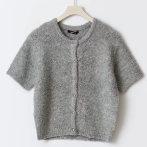 Grå kofta från Gina Tricot - Superfin kortärmad kofta från Gina tricot i stl XS. Helt nyskick med lappen fortfarande kvar. Orginal priset är 399 kr