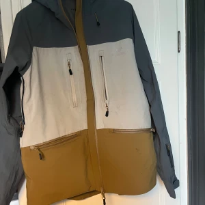 Skidjacka - Säljer en cool flerfärgad jacka från Gridarmor i storlek S. Jackan har en kombination av grå, beige och brun färg med praktiska dragkedjor och en stor huva. Perfekt för skidåkning och liknande med snölås och tejpade sömmar. Använd några gånger men i bra skick! Nypris ligger på strax över 2500kr. Vid frågor hör av dig! 