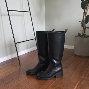 Svarta stövlar från Zara - Svarta stövlar med robust klack. Perfekta för höst och vinter, dessa stövlar ger en stilren look och är både bekväma och hållbara. Passar bra till både vardag och fest.