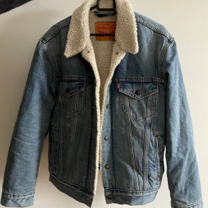 Jeansjacka med teddyfoder från Levi's - Säljer en snygg jeansjacka från Levi's i storlek S. Den har ett mysigt teddyfoder som gör den perfekt för höst och vinter. Jackan är i bra skick och har knappar framtill. Snygg till vardag och är använd fåtal gånger! 😍❤️ nypris: 1500  mitt pris: 800