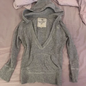 Grå hoodie från Abercrombie & Fitch -  grå stickad hoodie från Abercrombie & Fitch i bra skick. skriv om frågor