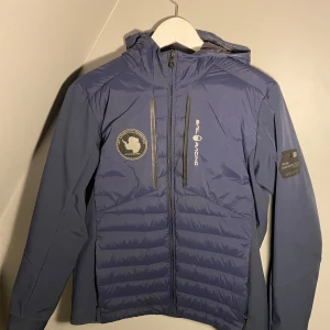 Blå jacka från Sail Racing - Säljer en snygg blå jacka från Sail Racing i mycket bra skick. Jackan är mycket bra skick. Använd cirka 3 månader. Inga skador eller fel. Unisex strl 170, herrstorlek xs