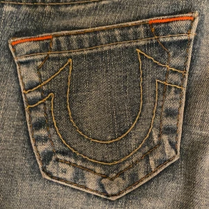 Blå jeans från True Religion - Säljer ett par snygga blå jeans från True Religion i storlek 25. De har en låg midja och är Boot cut som sitter perfekt. Klassisk design med märkets ikoniska fickdetaljer. Perfekta för både vardag och fest! Säger dom här eftersom dom tyvär var för små❤️ kan förhandla priset om det är en snabb affär