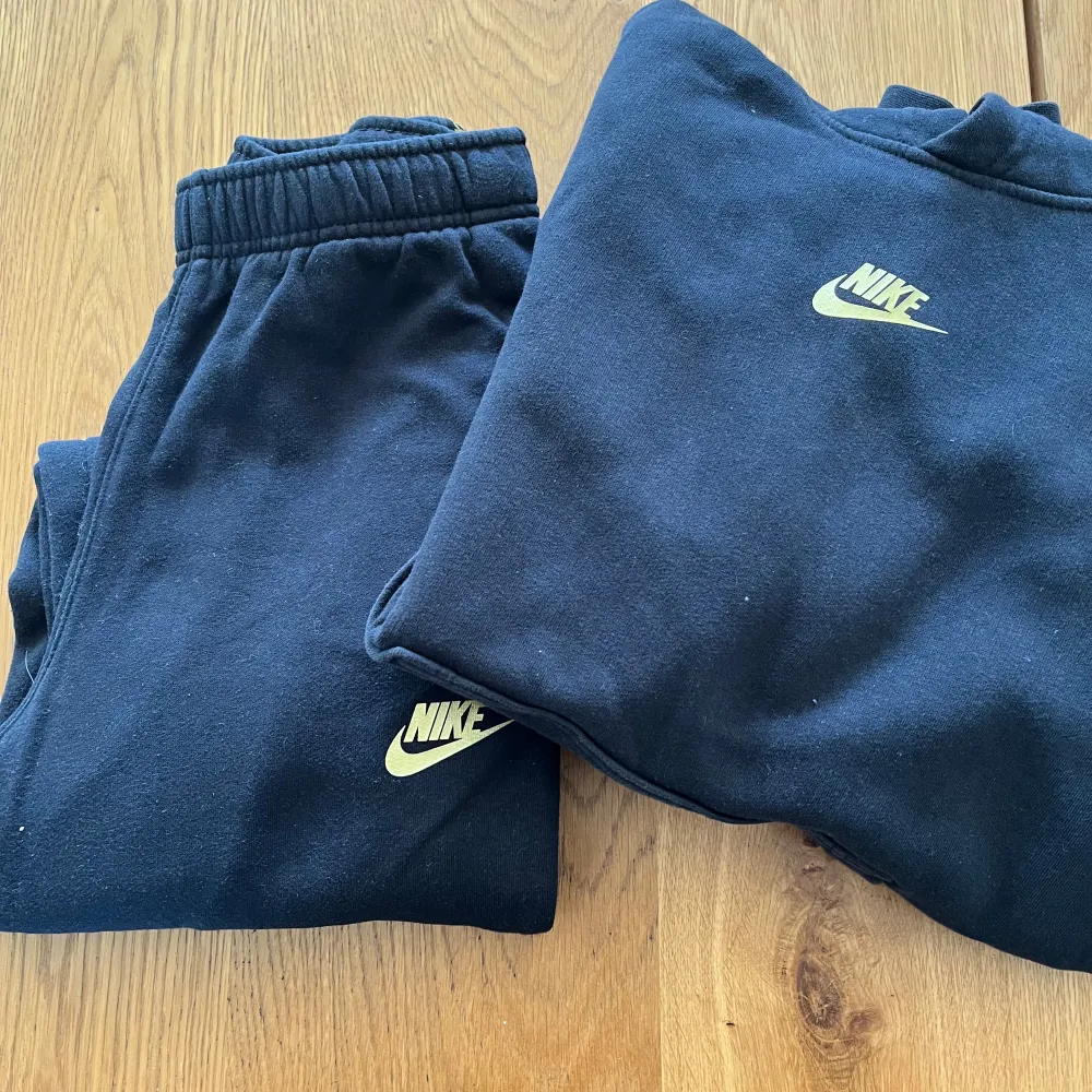 NIKE ställ  byxa och hoddie i stl.150. NIKE texten är guldfärgad. Använt men bra skick. . Sportswear.