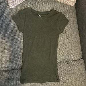Olivgrön t-shirt - Olivgrön t-shirt i storlek S (som XS). Om jag minns rätt så är den inköpt på Primark. Inga konstigheter 