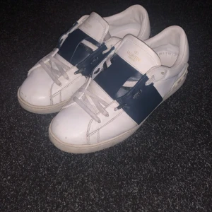 Valentino sneakers i vitt och blått - Säljer ett par snygga Valentino open skor. dom är i stolek 43 men passar 42. tvär så har jag inte box eller kvitto därför säljer jag biligt. 7.5/10 skick. hör av dig om du har funderingar eller nåt liknade.