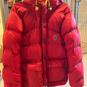 Fjällräven dunjacka - Dunjacka fjällräven, äldre modell och vad lite skavanker! Behöver en tvätt och har några lagningar (se bilder), dragkedjan behöver också sys om nedtill på jackan (se bild) men inget som annars syns när jackan är stängd. Passar S eller liten M 