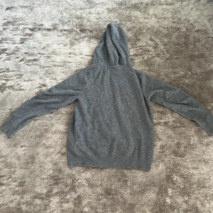 Kashmir hoodie - Den här grå kashmirtröjan är definitionen av lyx och komfort. Tillverkad av 100% ren kashmir, erbjuder den en oöverträffad mjukhet och värme som håller dig stilfullt klädd året runt. Ny pris på en Kashmir hoodie ligger runt 1500-3000kr 