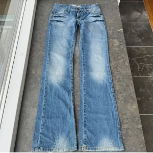 Blå bootcut jeans - Jättefina utsvängda jeans köpta här på Plick (bilderna är lånade), de var tyvärr för små så de kom aldrig till användning!! Midjemåttet är 37 cm och innerbenslängden är 86 cm. Jättebra skick, finns dock ett pyttelitet hål i låret men som inte syns när man har på de (se sista bilden)💞 