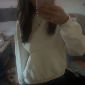Vit hoodie - Säljer en stilren vit hoodie med en avslappnad passform. Perfekt för kyliga dagar och att mysa i hemma. Den har en klassisk design med långa ärmar och en bekväm huva.