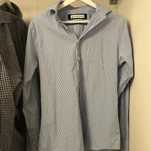 Blårutig skjorta från The Shirt Factory - Snygg blårutig skjorta från The Shirt Factory i slim fit. Skjortan har långa ärmar och klassisk krage, perfekt för en stilren look. Tillverkad i ett lätt och bekvämt material som är enkelt att tvätta och bära. Nästan aldrig använd och är riktigt stekig