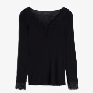 Svart långärmad topp med spetsdetaljer - Elegant svart långärmad topp från Intimissimi med v-ringad hals och spetsdetaljer vid halsringning och ärmslut. Supersnygg och vid bra skick!!💕 I storlek S men funkar för mig som har xs! Har tyvvär ett hål längst ut vid vänster arm!