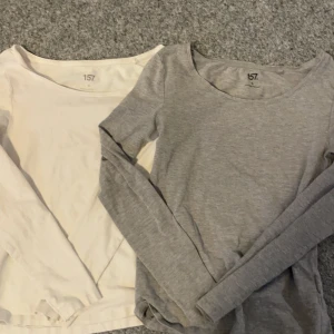 Två långärmade tröjor från 157 - Säljer två långärmade tröjor från 157 i färgerna grå och vit.  Tröjorna har en enkel design med rund halsringning.
