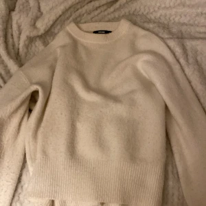 Vit stickad tröja från BikBok - Mysig vit stickad tröja från BikBok i storlek XS. Perfekt för kyliga dagar med sin mjuka och varma känsla. Tröjan har långa ärmar och ribbade kanter vid ärmslut och nederkant.