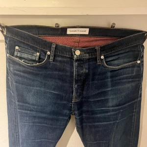  Samsøe Samsøe - Snygga mörkblå jeans från Samsøe Samsøe. Jeansen är väldigt detaljerade med röd insida och Samsøe Samsøe logan på alla knappar. Ny pris 3000kr mitt pris 300kr och det är pågrund av defekten på sista bilden dock den syns inte när man har på jeansen. Skriv om ni har den minsta lilla frågan🍾MVH VGClothing🍾(storlek 33/34)