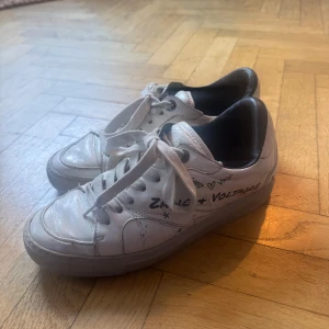 Vita sneakers Zadig & Voltaire  - Snygga vita sneakers med unikt tryck och snörning. Perfekta för en casual look med en twist. Skorna har en klassisk design med en modern touch.