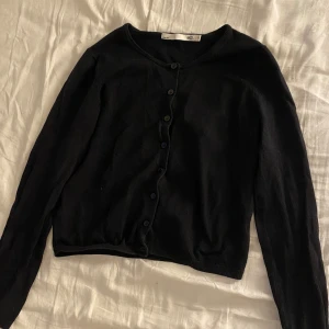 Svart kofta från Lager 157 - Säljer en stilren svart kofta från Lager 157. Den har långa ärmar och knappar framtill. Perfekt för lager-på-lager under kyligare dagar. Passar till många olika outfits!