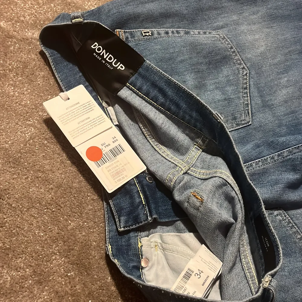 Snygga blå jeans från Dondup, modellen Icon med en klassisk femficksdesign. Straight passform och är tillverkade i ett slitstarkt denimtyg. Otroligt sköna och passar en avslappnad stil. Extra bra till vår och sommar! Passar bäst mellan 180-190 cm. Köpta i butik, nypris - 3000kr. Vårt pris - 449kr. Tag från bild 4 medkommer.. Farkut & Housut.