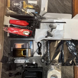 Hårklippningsset med rakapparat och tillbehör - Komplett hårklippningsset med rakapparat från Lancer, flera kammar, sax, laddningskabel och en flaska barberolja. Perfekt för hemmabruk eller professionell styling.